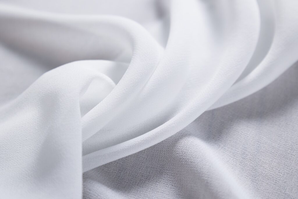 39115 Elegant white semi-sheer soft 50D chiffon fabric by the yard. It's a beautiful drape and crepe-like texture chiffon, a very soft and lightweight chiffon material for making dresses and skirts.